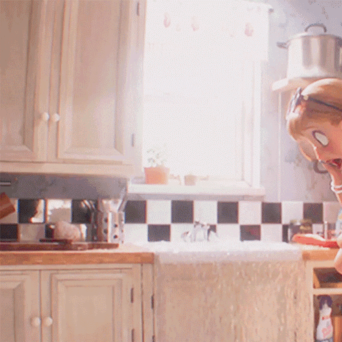 A Woman Wearing Sunglasses Is Sitting In A Kitchen GIF