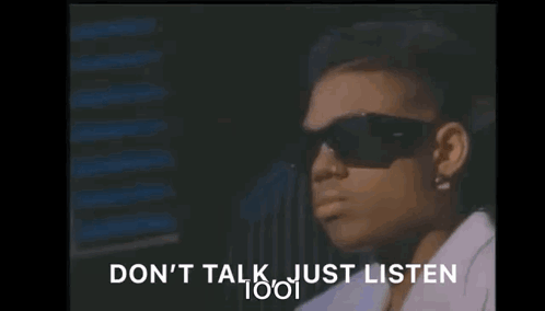 A Woman Wearing Sunglasses Is Sitting In Front Of A Window And Says `` Do N't Talk Just Listen '' . GIF