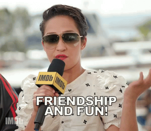 A Woman Wearing Sunglasses Is Talking Into A Microphone That Says Friendship And Fun GIF