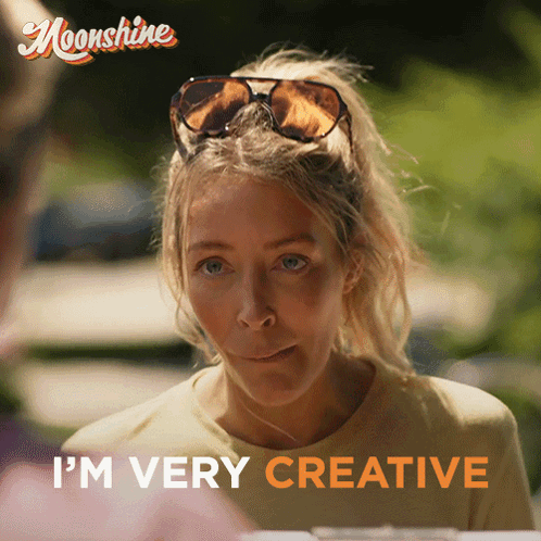 A Woman Wearing Sunglasses Says " I 'M Very Creative " In Orange Letters GIF