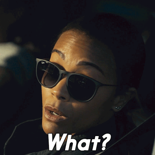 A Woman Wearing Sunglasses Says " What " In White Letters GIF