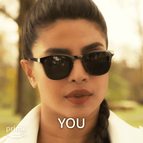 A Woman Wearing Sunglasses Says " You " In Front Of Her GIF