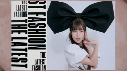 A Woman With A Black Bow On Her Head Is On The Cover Of A Magazine That Says The Latest Fashion GIF