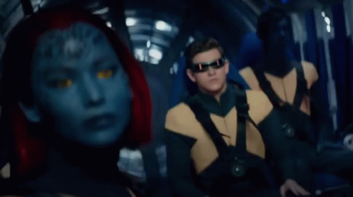 A Woman With A Blue Face And Red Hair Looks At The Camera GIF