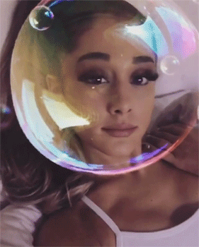 A Woman With A Bubble On Her Head Looks At The Camera GIF