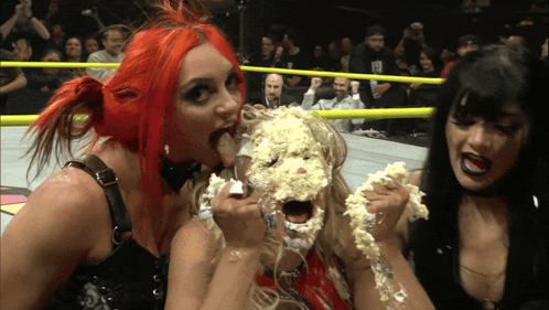 A Woman With A Cake On Her Face Is Surrounded By Two Women GIF
