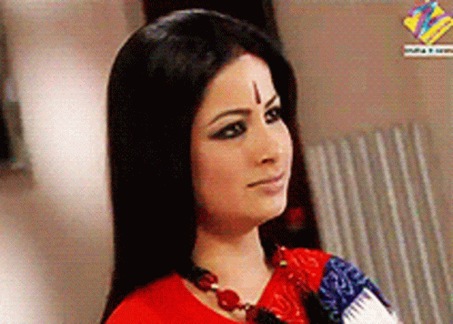 A Woman With A Cross On Her Forehead Wears A Red Shirt GIF