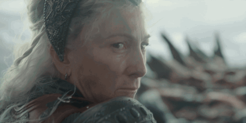 A Woman With A Crown On Her Head Is Looking Over Her Shoulder GIF