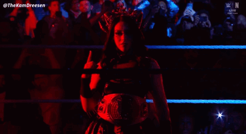 A Woman With A Crown On Her Head Is Standing In A Wrestling Ring GIF