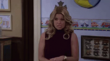 A Woman With A Crown On Her Head Is Standing In Front Of A Wall With A Picture Of A Fire Truck On It GIF