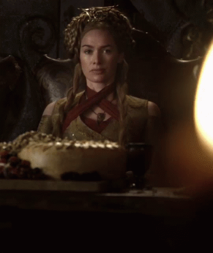 A Woman With A Crown On Her Head Sits In A Chair GIF