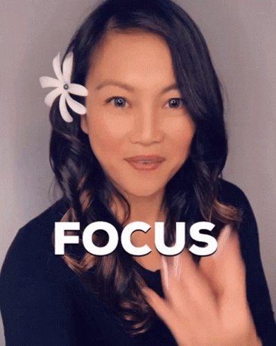 A Woman With A Flower In Her Hair Has The Word Focus Above Her Head GIF
