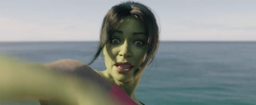 A Woman With A Green Face Is Standing In The Ocean GIF