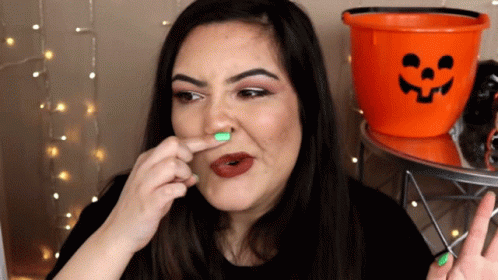 A Woman With A Green Nail Polish On Her Nose GIF