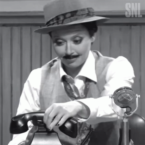 A Woman With A Hat And Mustache Is Talking On A Telephone With The Snl Logo In The Corner GIF