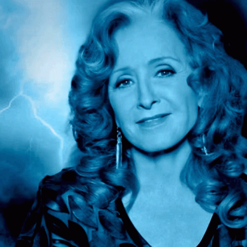 A Woman With A Lightning Bolt In The Background Looks At The Camera GIF
