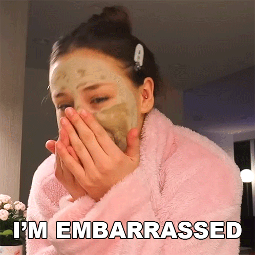 A Woman With A Mask On Her Face Is Covering Her Mouth With Her Hands And The Words I 'M Embarrassed Are Above Her GIF