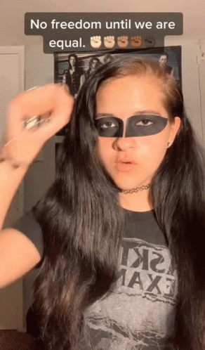 A Woman With A Mask On Her Face Is Wearing A T-Shirt That Says Maxf GIF