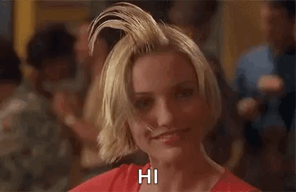 A Woman With A Mohawk On Her Head Is Smiling And Says Hi . GIF