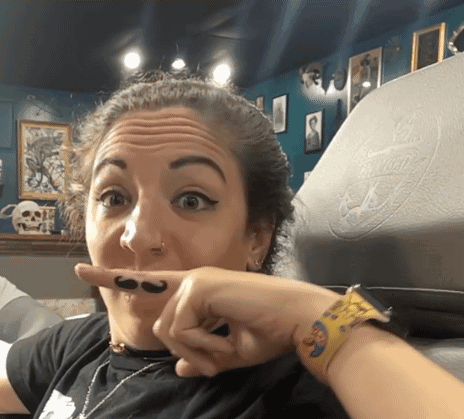A Woman With A Mustache On Her Finger GIF