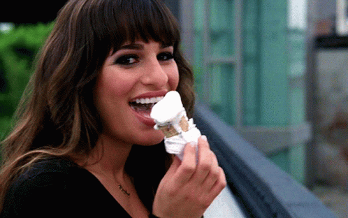 A Woman With A Necklace That Says ' I Love You ' On It Is Eating Ice Cream GIF