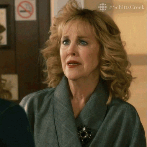 A Woman With A No Smoking Sign On The Wall Behind Her GIF