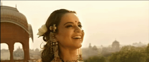 A Woman With A Nose Ring And A Flower In Her Hair Smiles GIF