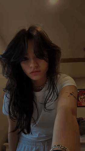 A Woman With A Nose Ring And A Tattoo On Her Arm GIF
