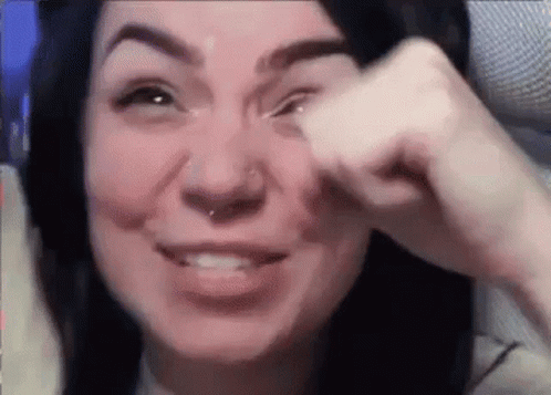 A Woman With A Nose Ring Is Crying While Holding Her Hand To Her Eye . GIF