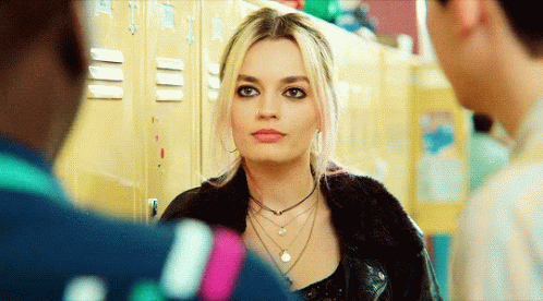 A Woman With A Nose Ring Is Standing In Front Of A Row Of Lockers GIF