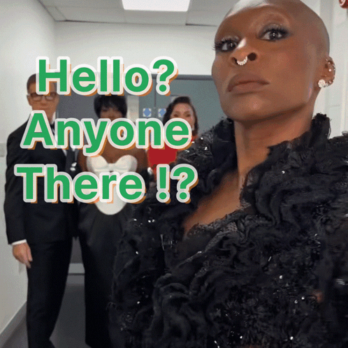 a woman with a nose ring stands in front of a sign that says hello anyone there !