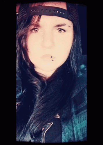 A Woman With A Piercing In Her Lip And A Hat On Her Head GIF
