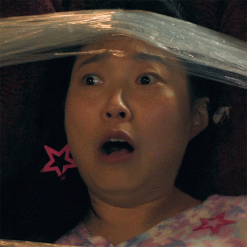 A Woman With A Pink Star Earring Is Covered In Plastic Wrap GIF