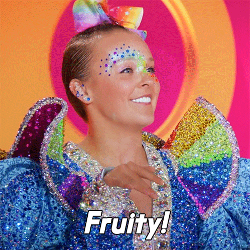a woman with a rainbow bow on her head is wearing a colorful dress and says fruity