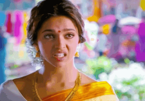 A Woman With A Red Dot On Her Forehead Is Wearing A Yellow And White Saree GIF