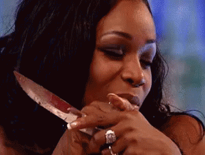 a woman with a ring on her finger is holding a knife in her hand .