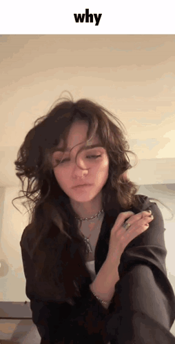 A Woman With A Ring On Her Finger Is Looking At The Camera With The Word Why Above Her GIF