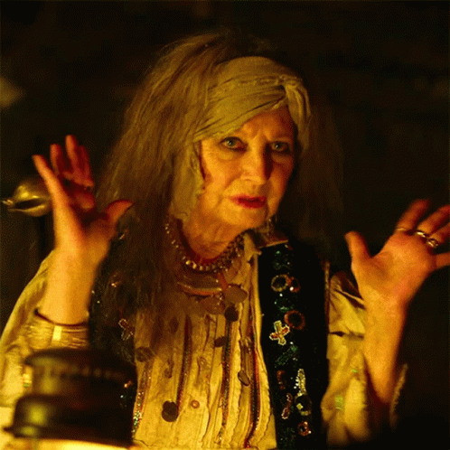 A Woman With A Scarf Around Her Head Is Making A Strange Gesture GIF