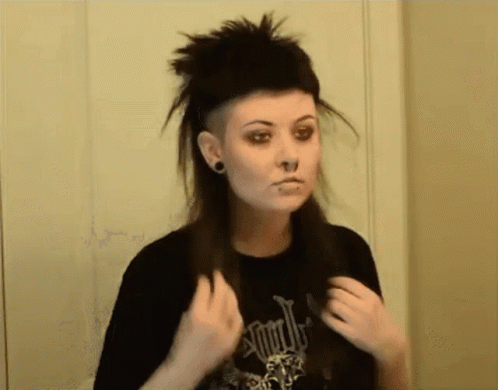 A Woman With A Shaved Head And A Black Shirt That Says ' Apocalypse ' On It GIF