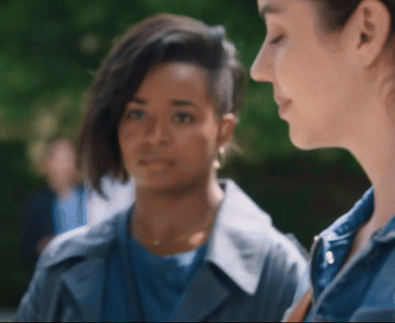 A Woman With A Shaved Head Looks At Another Woman GIF