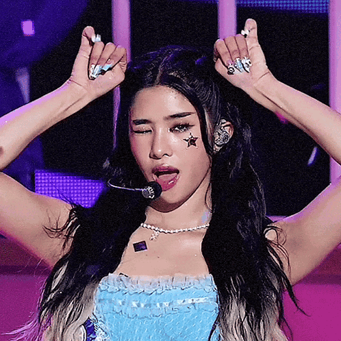 A Woman With A Star On Her Forehead Is Wearing A Microphone GIF