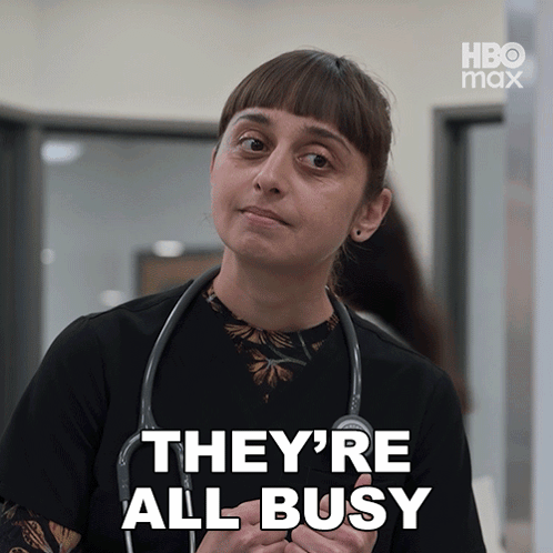 A Woman With A Stethoscope Around Her Neck Says They 'Re All Busy In White Letters GIF