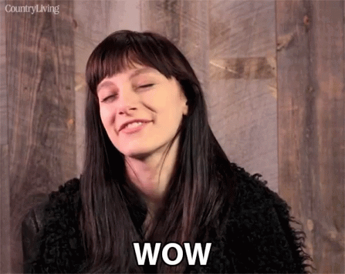 A Woman With A Surprised Look On Her Face And The Word Wow Written Below Her GIF