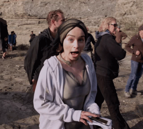 A Woman With A Surprised Look On Her Face Is Holding A Cellphone GIF