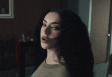 A Woman With A Surprised Look On Her Face Is Standing In A Dark Room GIF