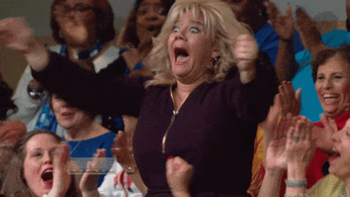 A Woman With A Surprised Look On Her Face Is Surrounded By Other People GIF