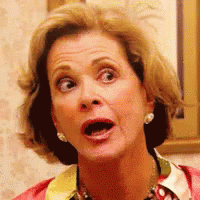 A Woman With A Surprised Look On Her Face Is Wearing Earrings . GIF
