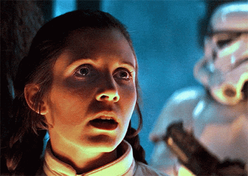 A Woman With A Surprised Look On Her Face Stands In Front Of A Storm Trooper GIF