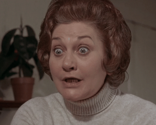 A Woman With A Surprised Look On Her Face Wearing A White Sweater GIF