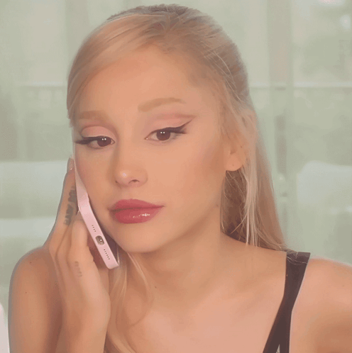 A Woman With A Tattoo On Her Arm Is Talking On A Phone GIF